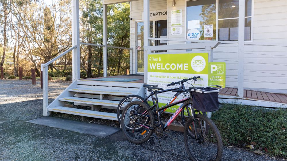 The Yea Riverside Caravan Park front office with two push bikes leaning up against the Welcome sign
